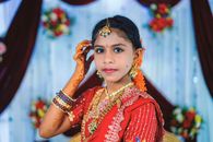 A young girl adorned in vibrant Indian traditional attire at a festive celebration.